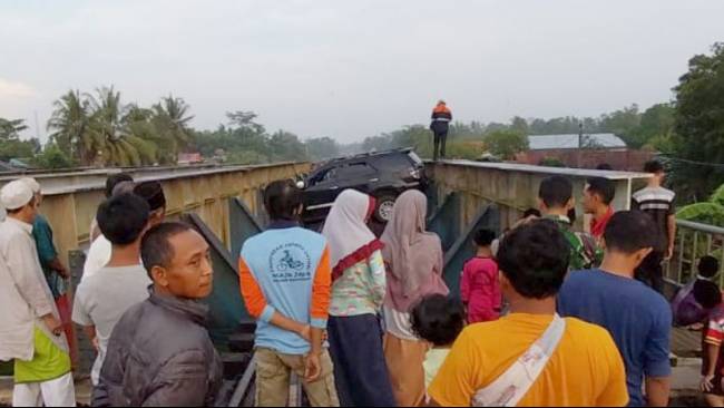 Warga menyaksikan sebuah mobil Fortuner yang melintang di atas viaduk setelah menyelonong masuk ke jalur rel kereta api melalui perlintasan sebidang Sumpiuh, Kabupaten Banyumas, Rabu (19/4/2023) pagi.
