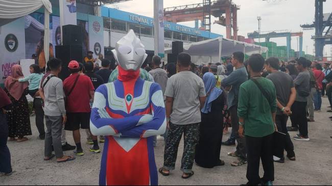 Iqbal Alam (24), peserta mudik gratis Kemenhub tampil berbeda dengan mengenakan kostum Ultraman di Pelabuhan Nusantara, Tanjung Priok, Jakarta Utara, Jumat (5/4/2024).