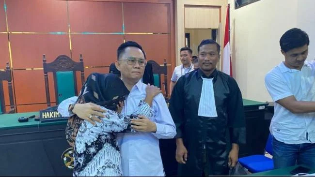 Guru honorer Supriyani menangis sambil memeluk kuasa hukumnya Andri Darmawan di PN Andoolo, Senin (25/11/2024). 
